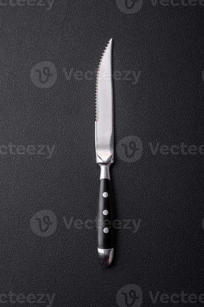 cuchillo de cocina de metal sobre un fondo de hormigón de textura oscura foto