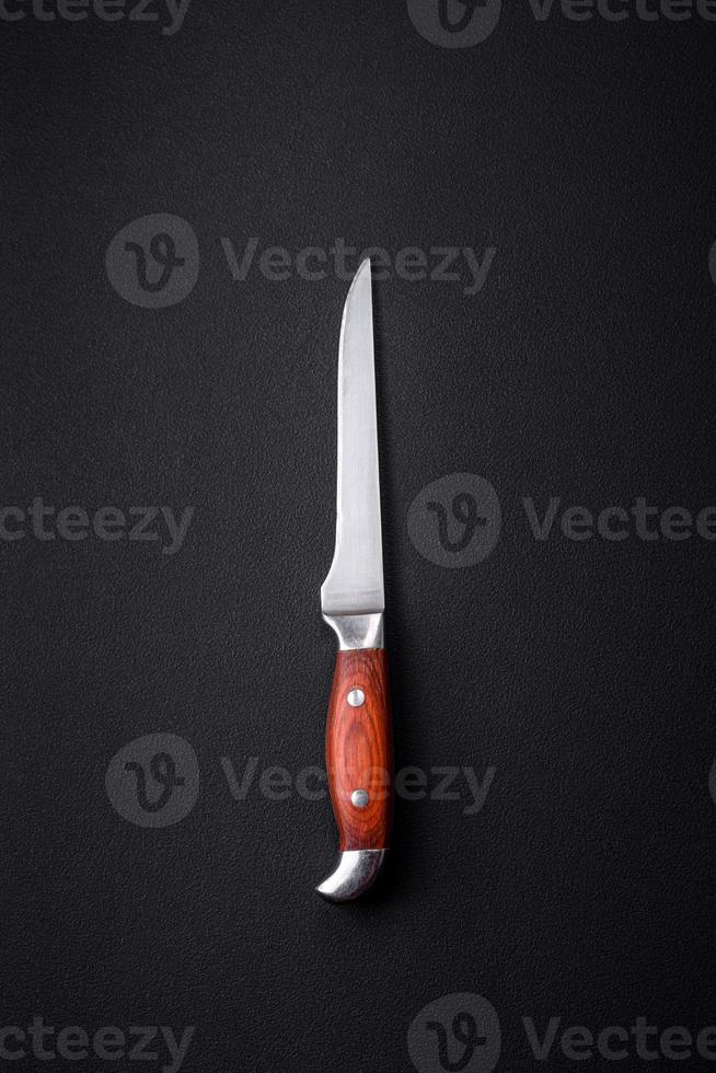 Metal kitchen knife on a dark textured concrete background photo