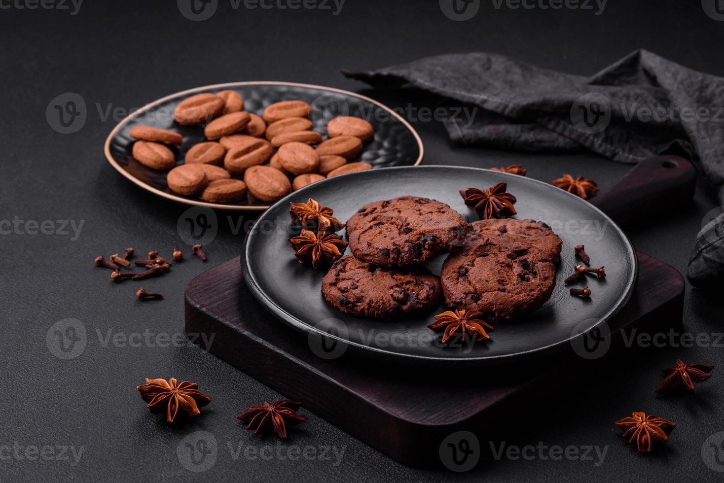 Delicious chocolate cookies with nuts on a black ceramic plate photo