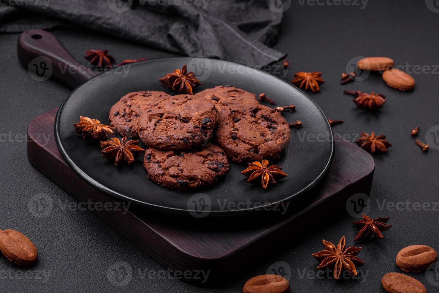 Delicious chocolate cookies with nuts on a black ceramic plate photo