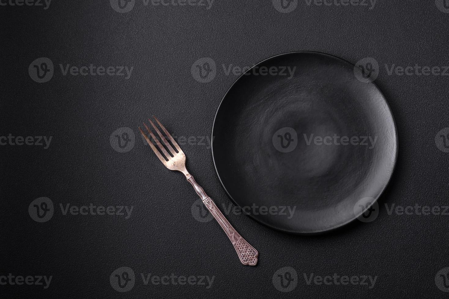 Empty ceramic round plate on dark textured concrete background photo