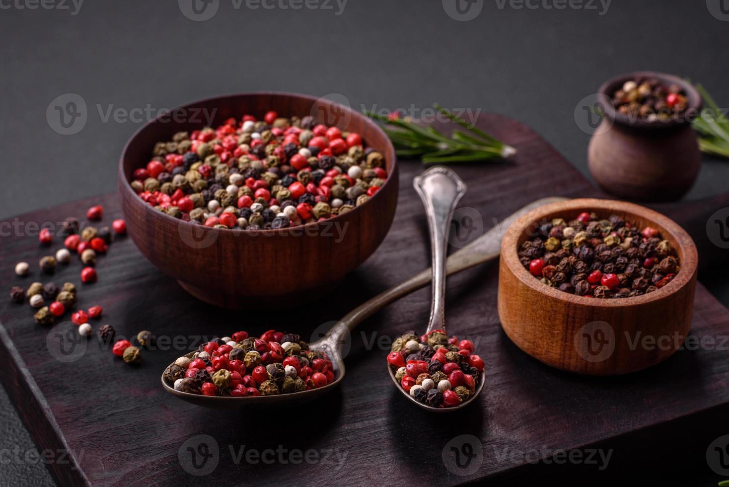 Spice allspice of different colors pink, white, green not ground in a wooden saucer photo