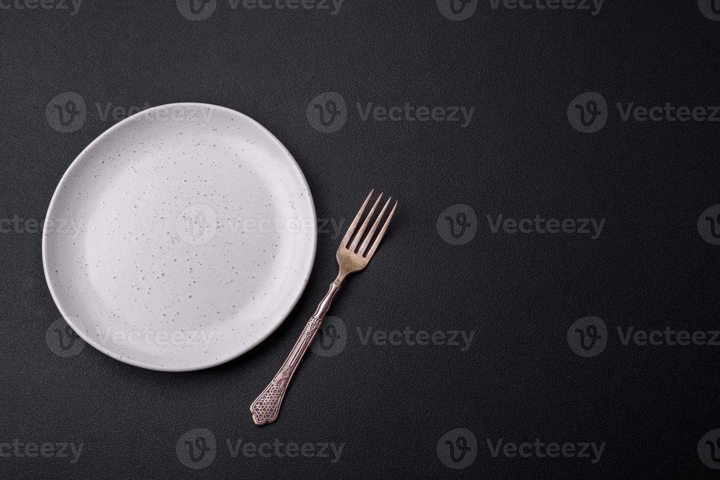 Empty ceramic round plate on dark textured concrete background photo