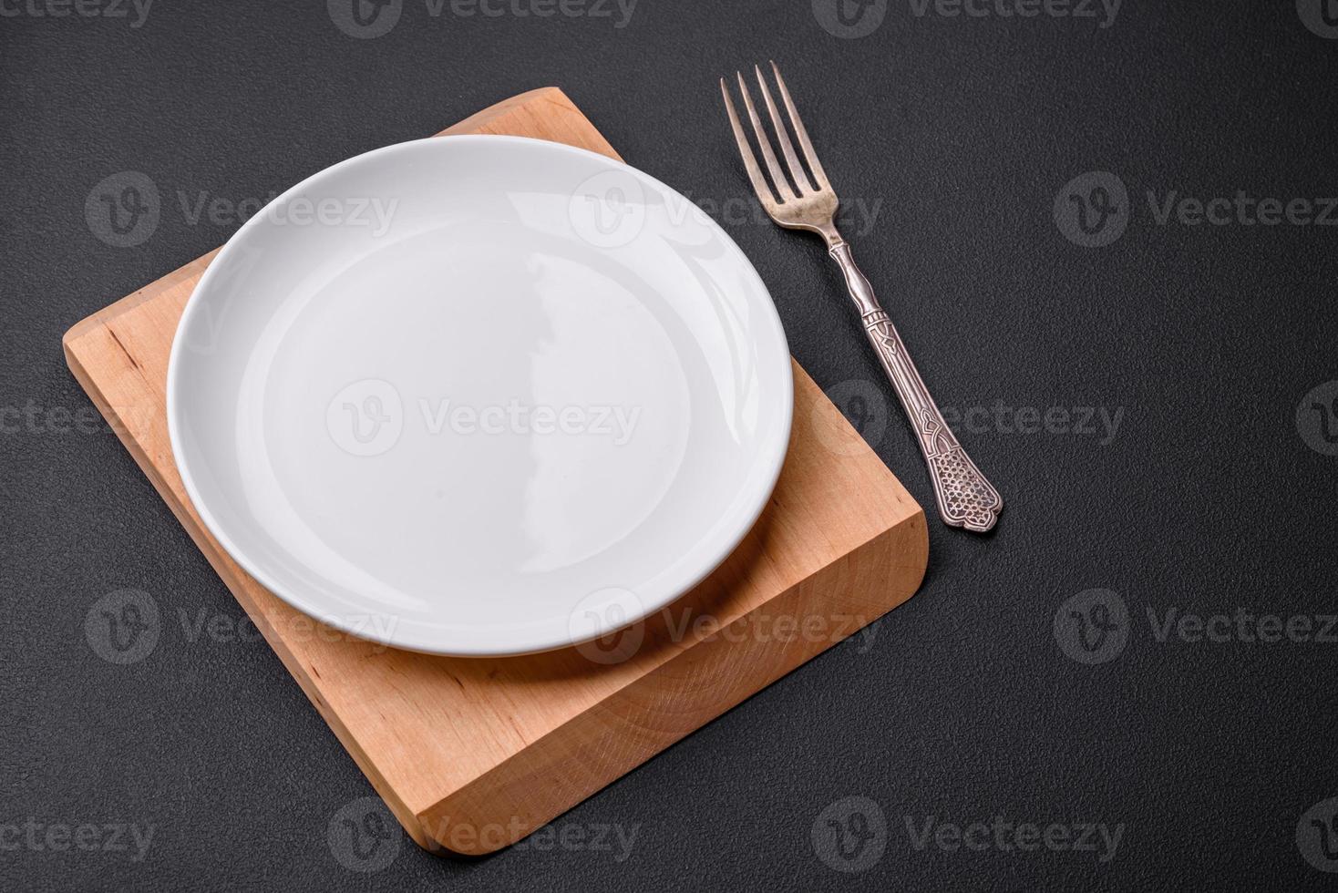 Empty ceramic round plate on dark textured concrete background photo