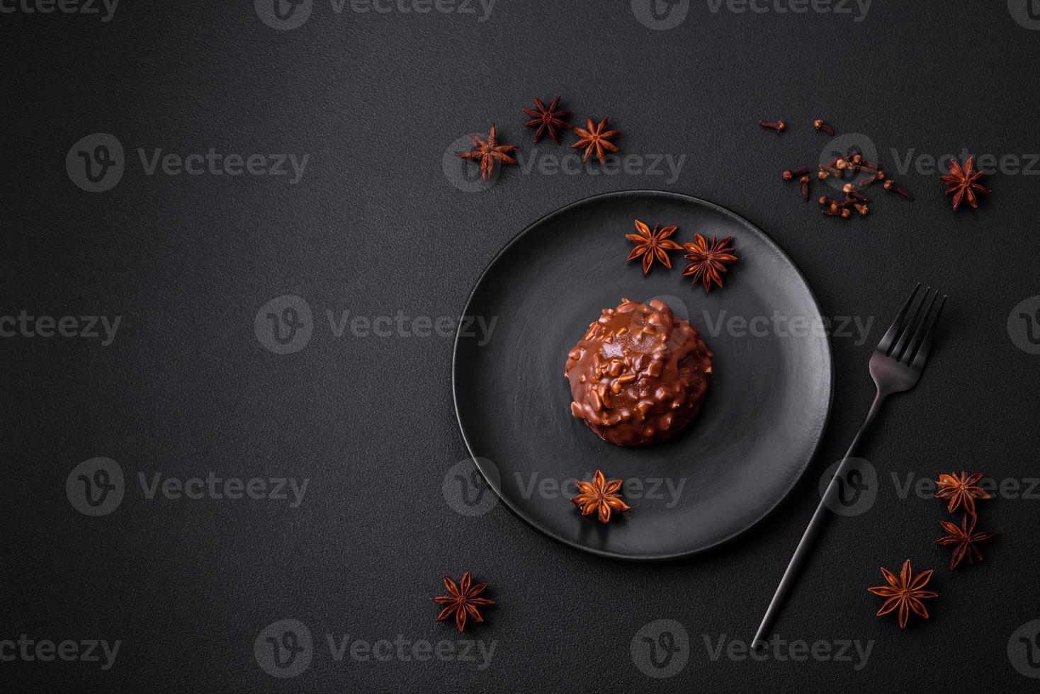Delicious chocolate tart with nuts on a black ceramic plate photo
