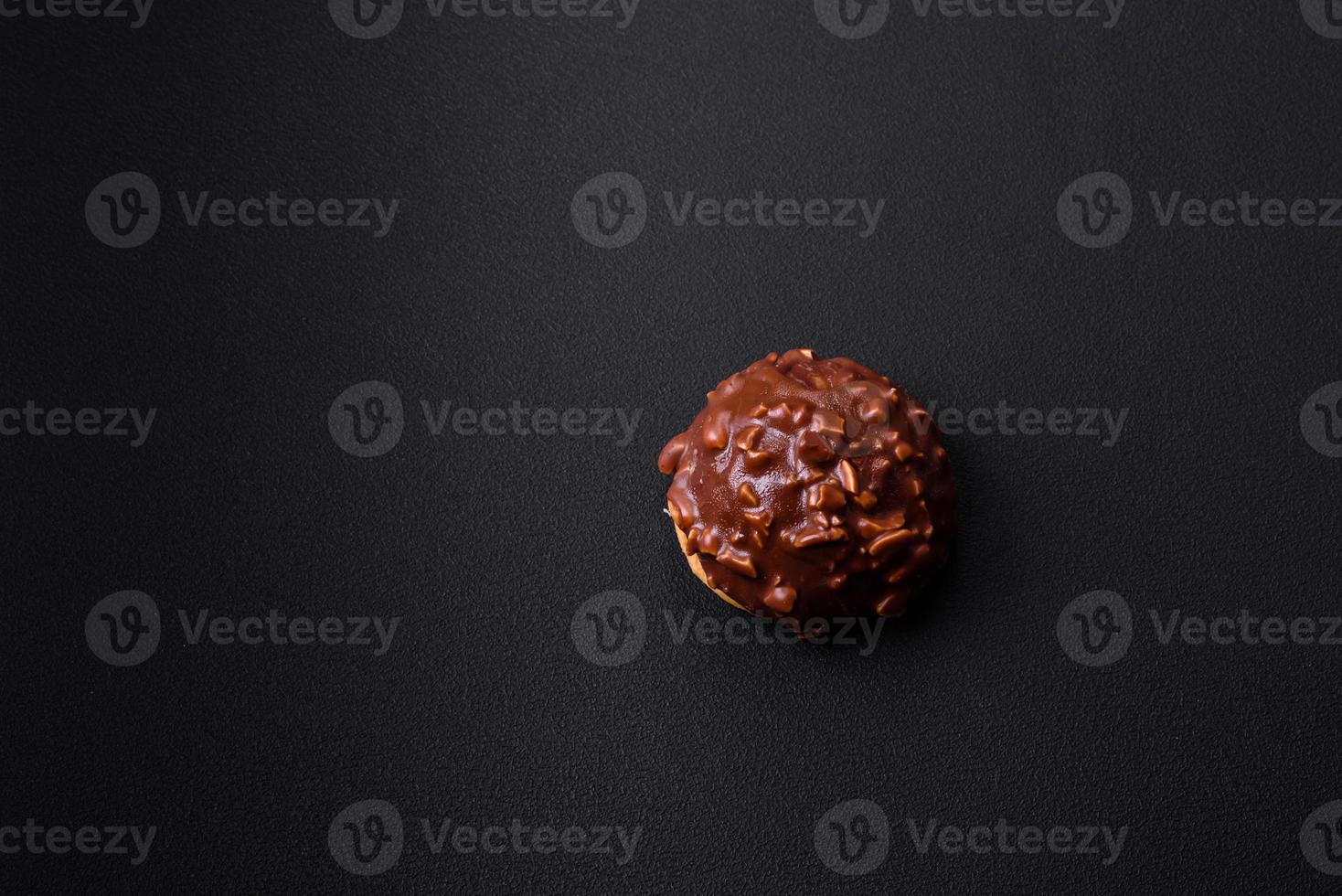 Delicious chocolate tart with nuts on a black ceramic plate photo