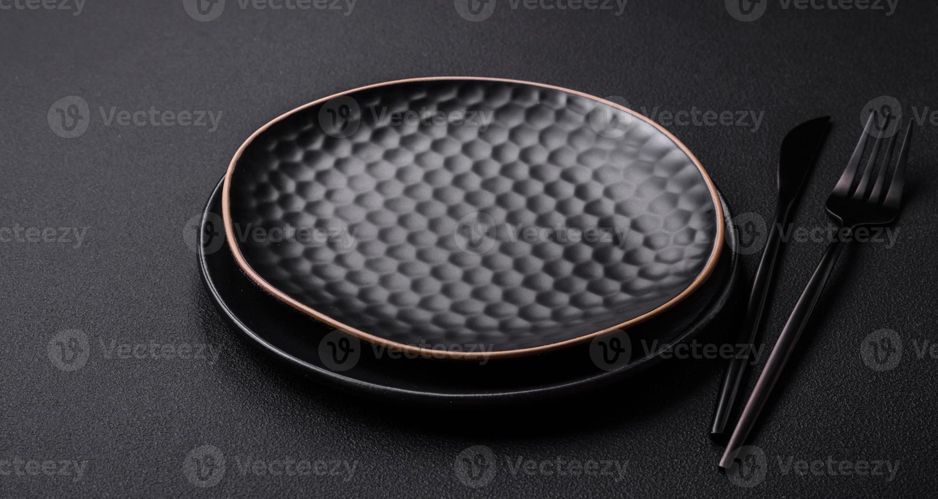 Empty ceramic round plate on dark textured concrete background photo