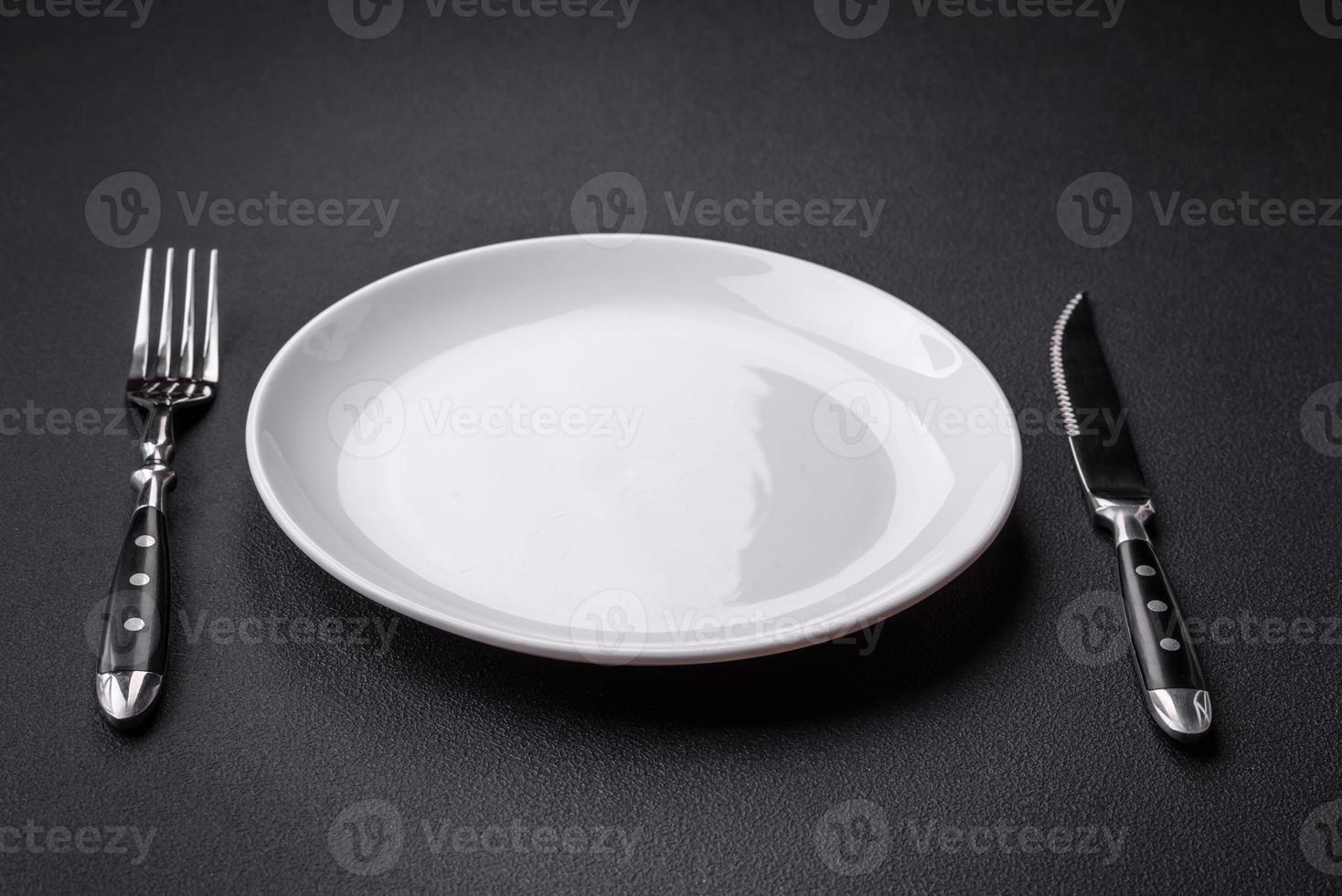 Empty ceramic round plate on dark textured concrete background photo