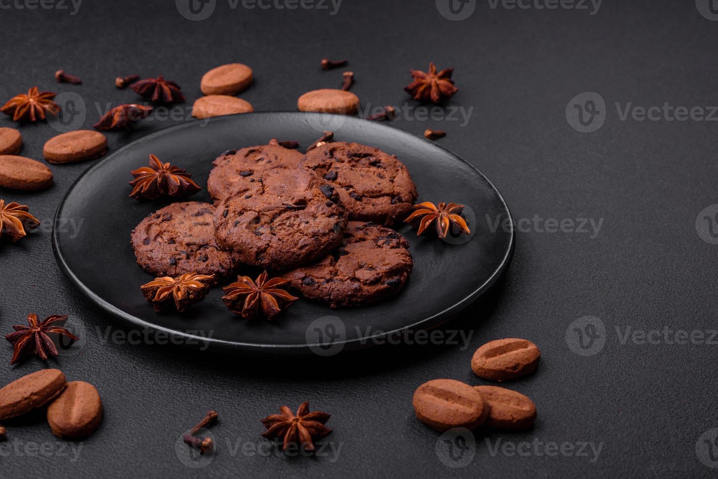 Delicious chocolate cookies with nuts on a black ceramic plate photo