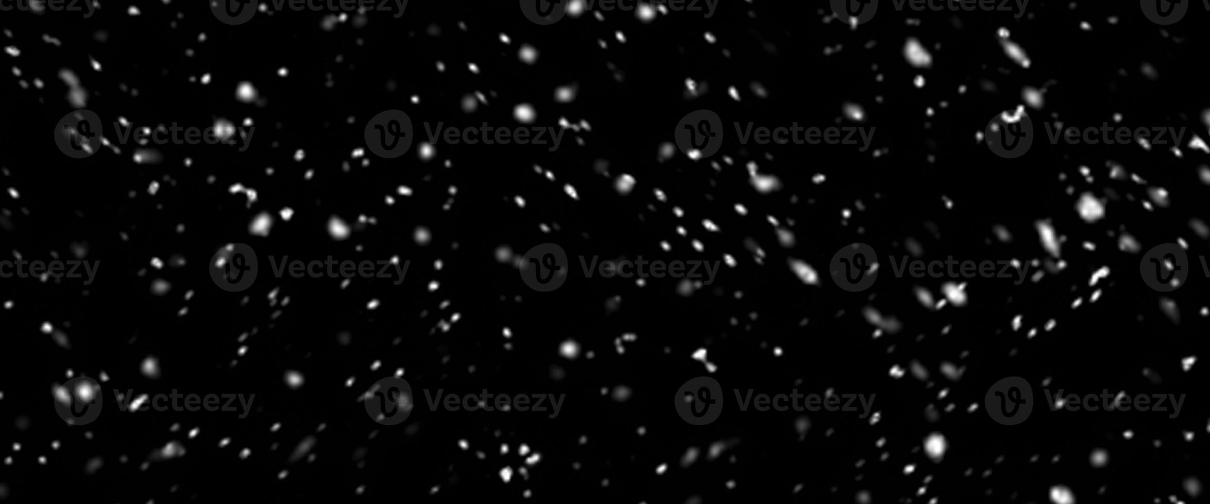 Falling snow isolated on black background. Falling snow at night. Bokeh lights on black background, flying snowflakes in the air. Winter weather. Overlay texture. photo