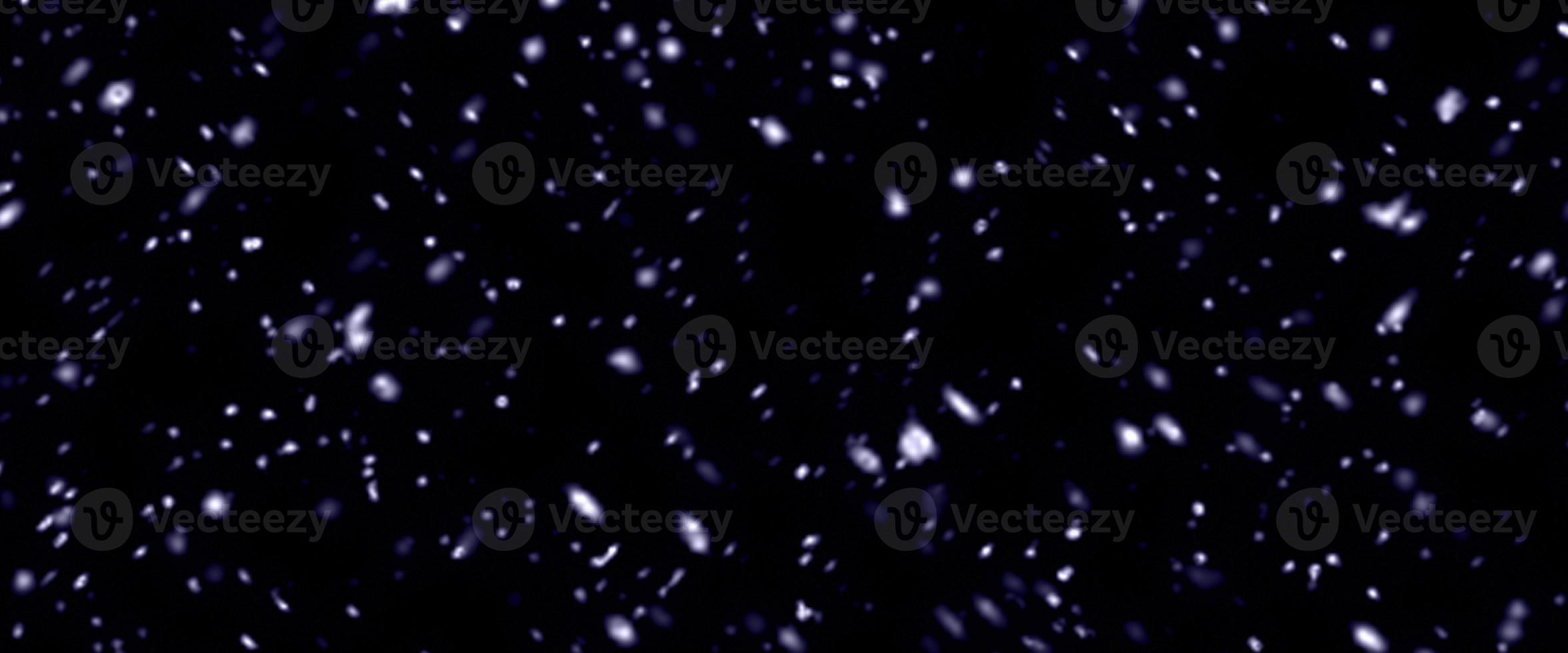 Falling snow isolated on black background. Falling snow at night. Bokeh lights on black background, flying snowflakes in the air. Winter weather. Overlay texture. photo
