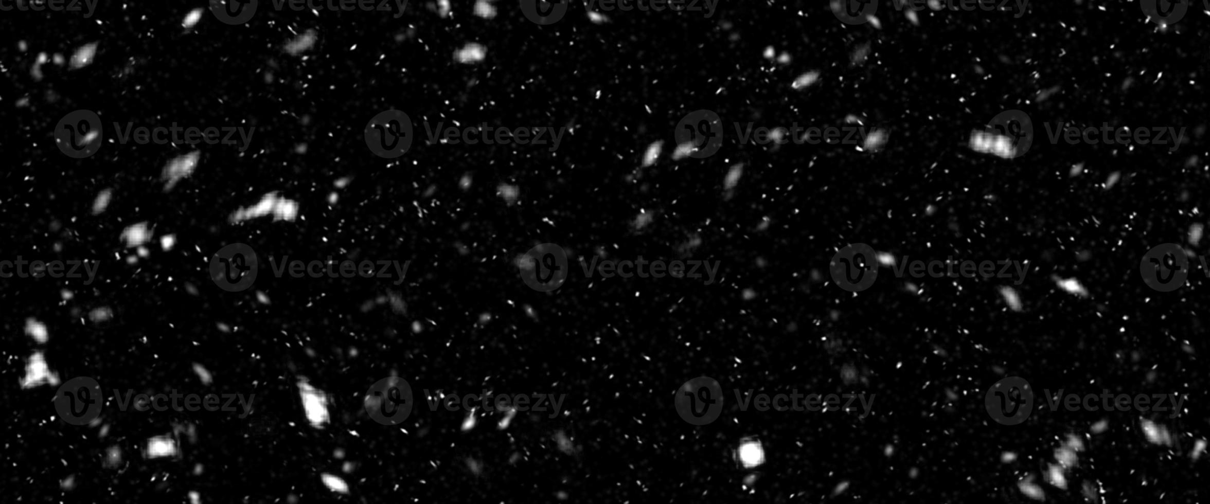 Falling snow isolated on black background. Falling snow at night. Bokeh lights on black background, flying snowflakes in the air. Winter weather. Overlay texture. photo