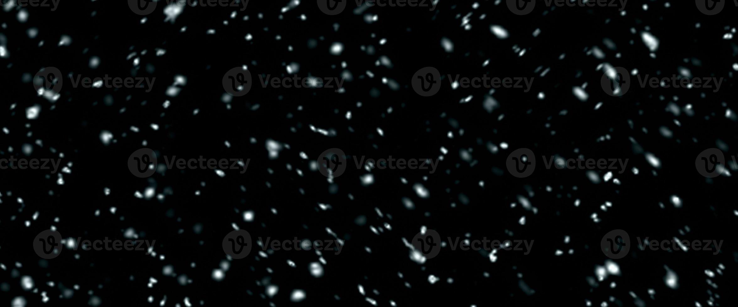 Falling snow isolated on black background. Falling snow at night. Bokeh lights on black background, flying snowflakes in the air. Winter weather. Overlay texture. photo