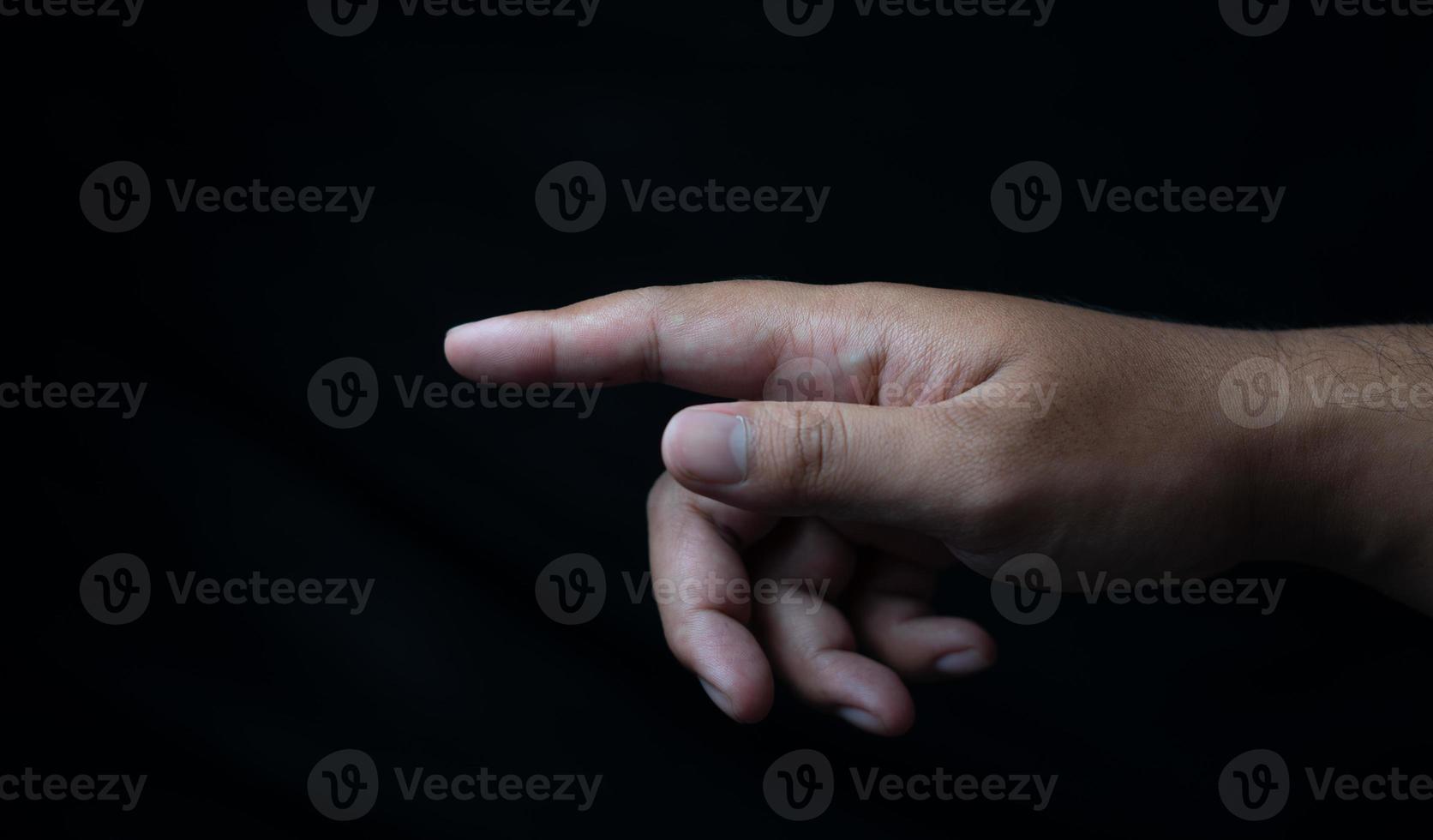 mano apuntando hacia adelante aislado en negro foto