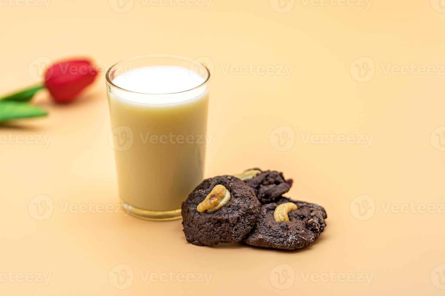 galletas de chocolate oscuro con pasas en su interior sobre el fondo de color naranja claro. foto