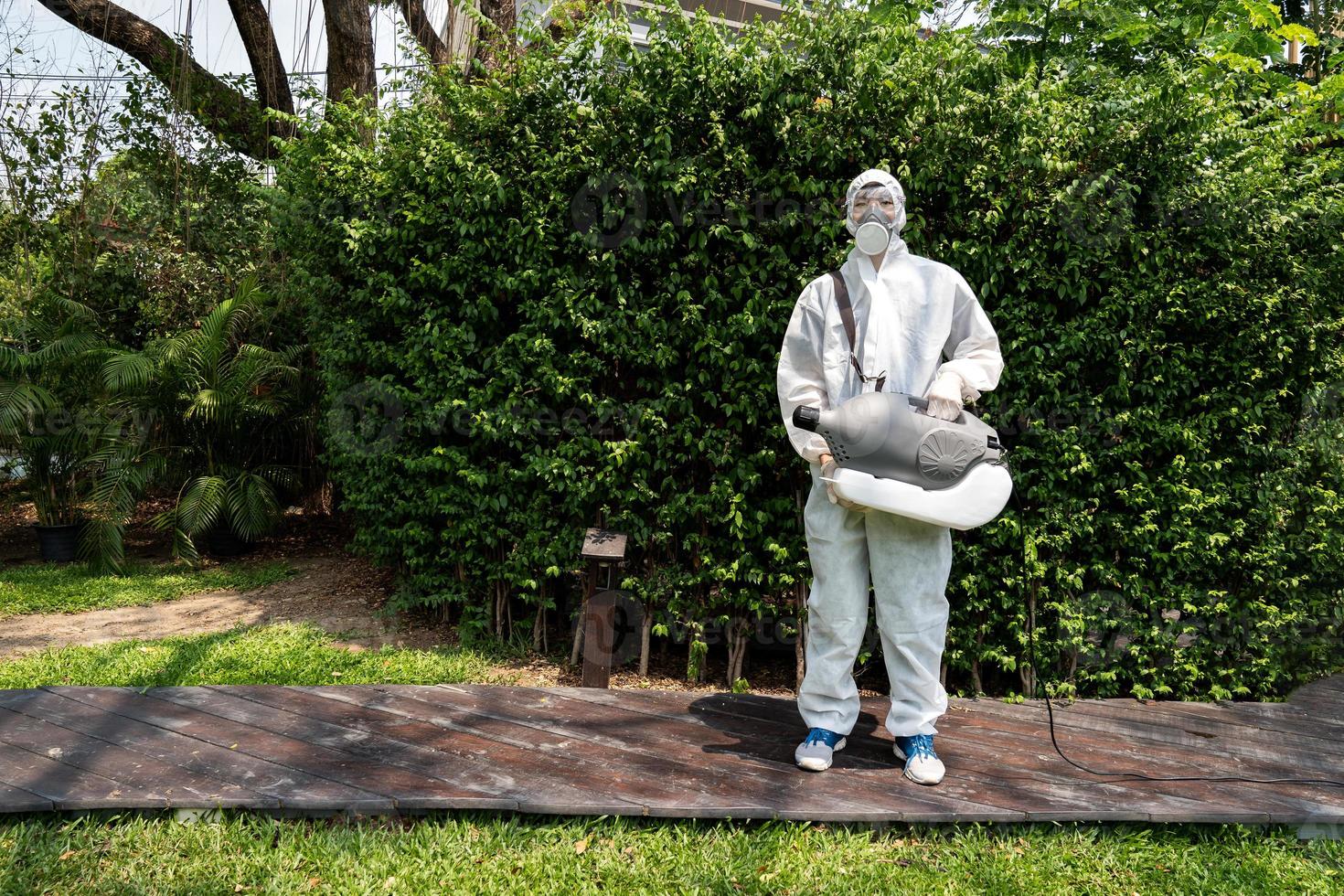 Professional technical man in prevention suit with his sterilizing machine and disinfecting water. He is ready to take purifying coronavirus COVID19 out. photo