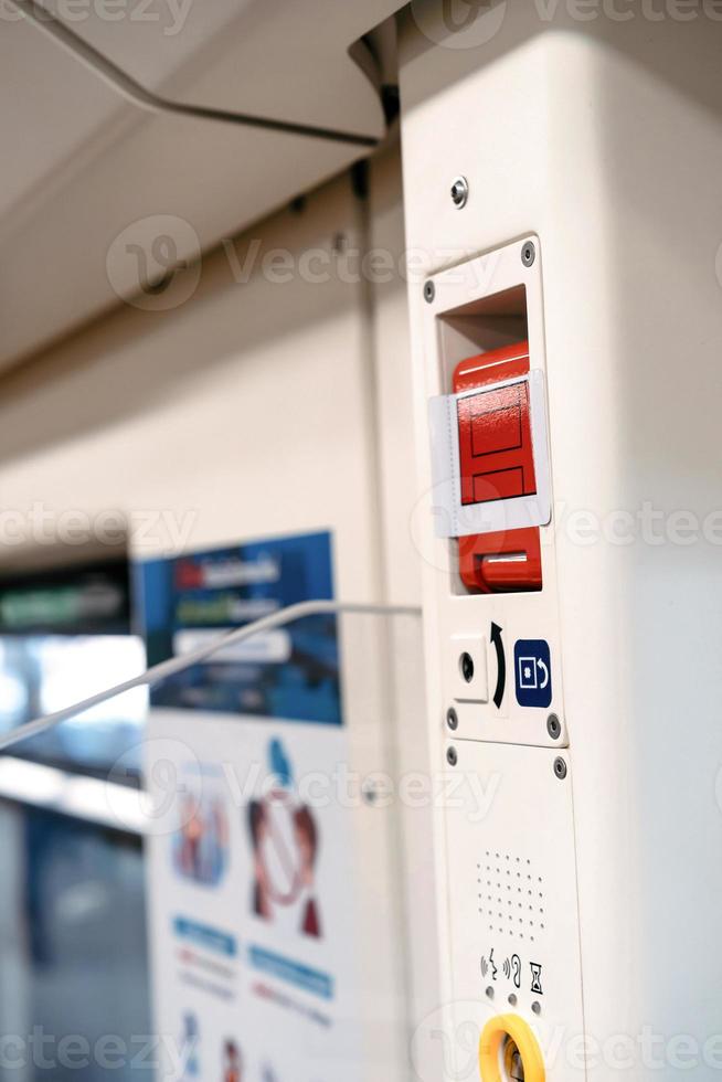 the red emergency door release switch control inside the sky train, it's set up beside the door. photo