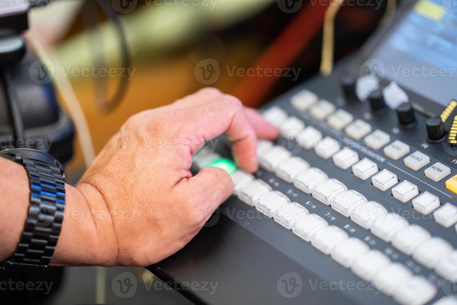 Focus on man's hand how control the livestreaming switcher board. photo