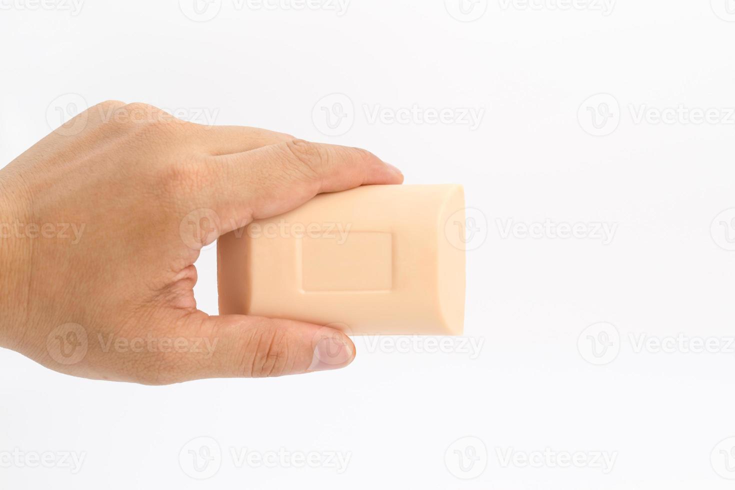 Asian mand hand holds rectangle cream color soap in studio light on white clear background. photo