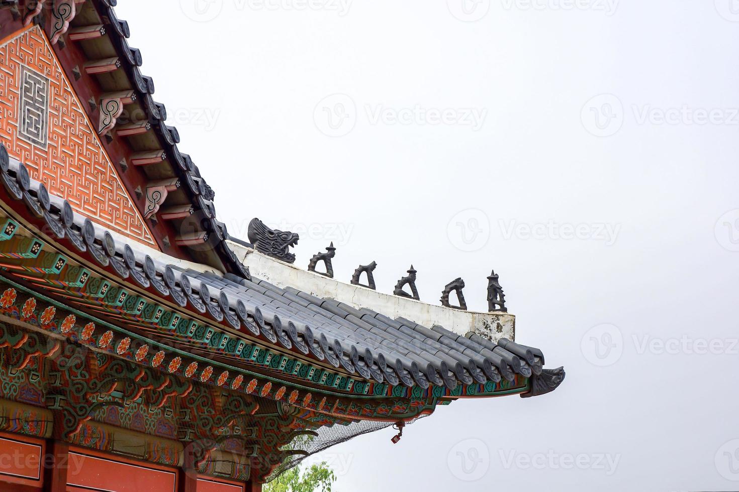 The historical Korea palace roof was decorated with the small statue on it. photo