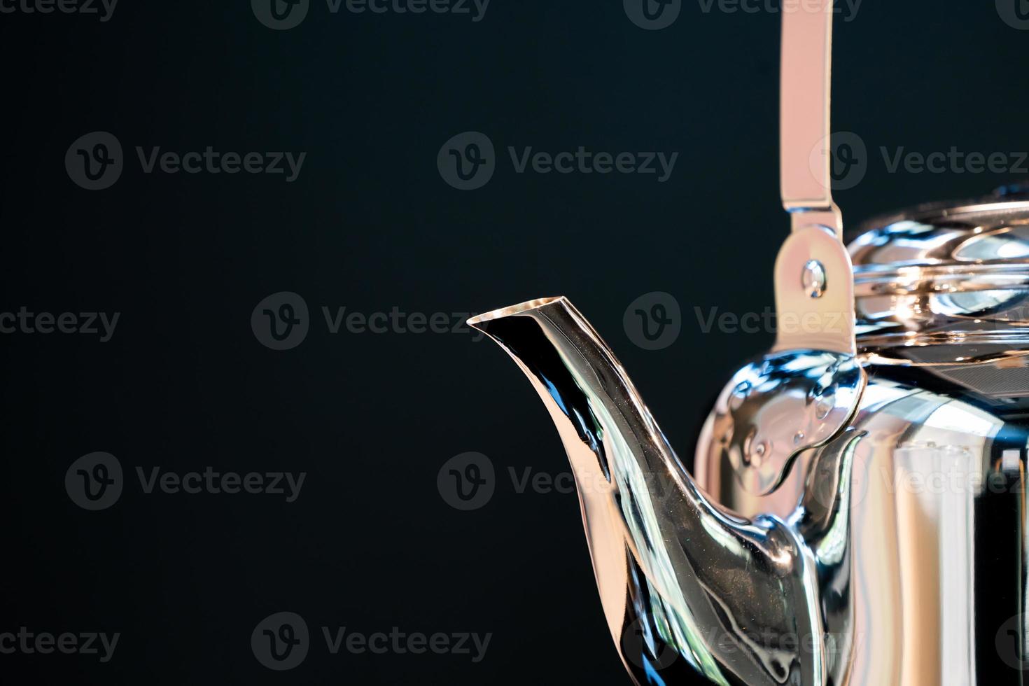 Stainless Water Crow or Vintage Kettle tea pot on electronic stove in modern dark blue background. photo