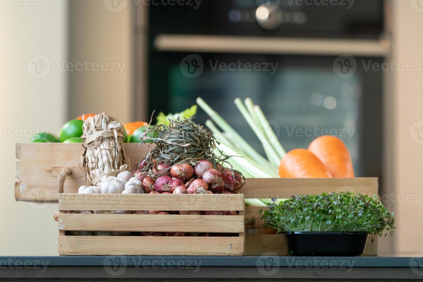 Group of vegetable Carrot, Potato, Lime, Tomato, Onion, Shallot bundle, Garlic bundle and Micro Herb in wood box. It's shot in studio light. photo