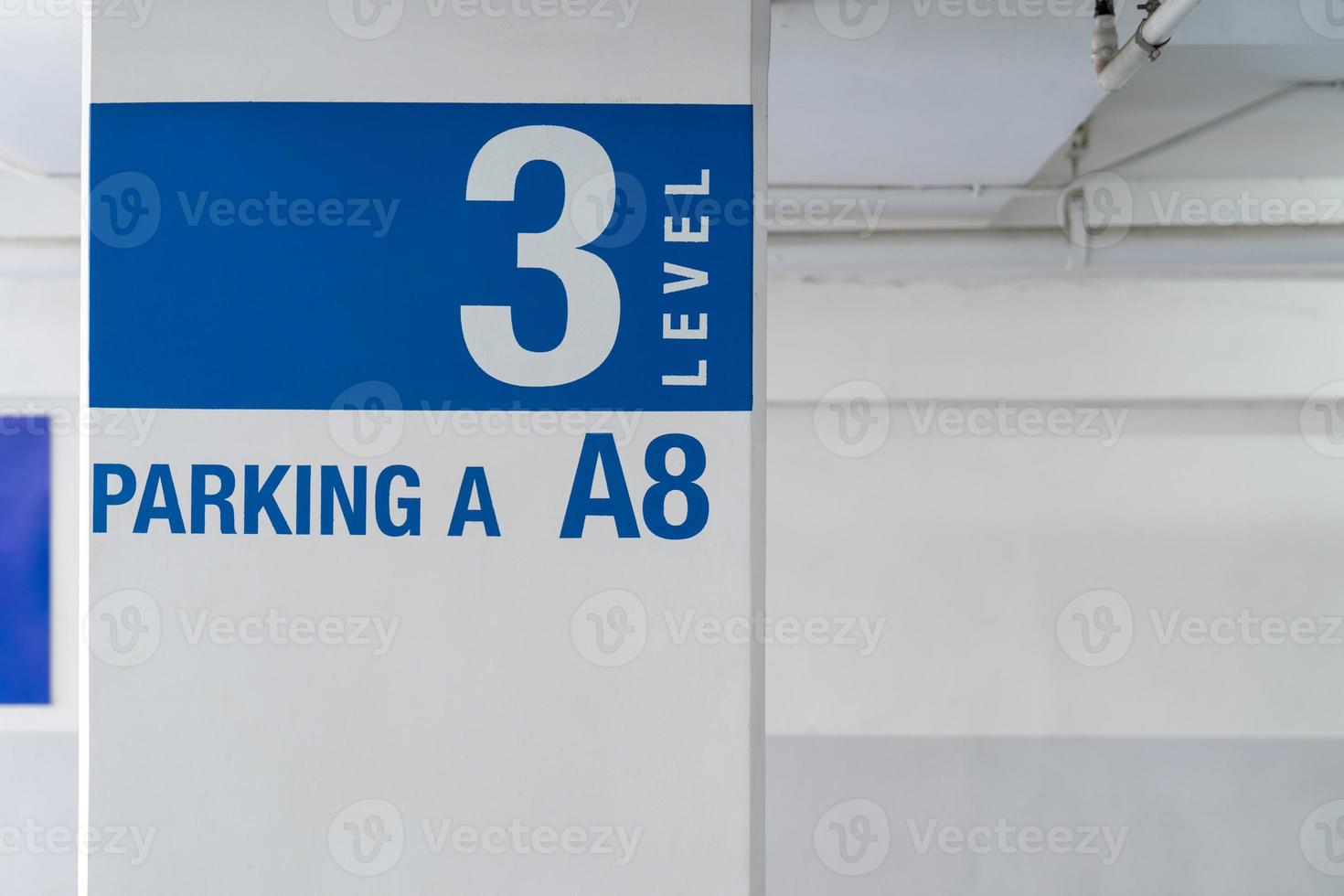 señalización en el poste de estacionamiento interior, dígale al conductor qué camino tomar y ubicación en el estacionamiento. foto