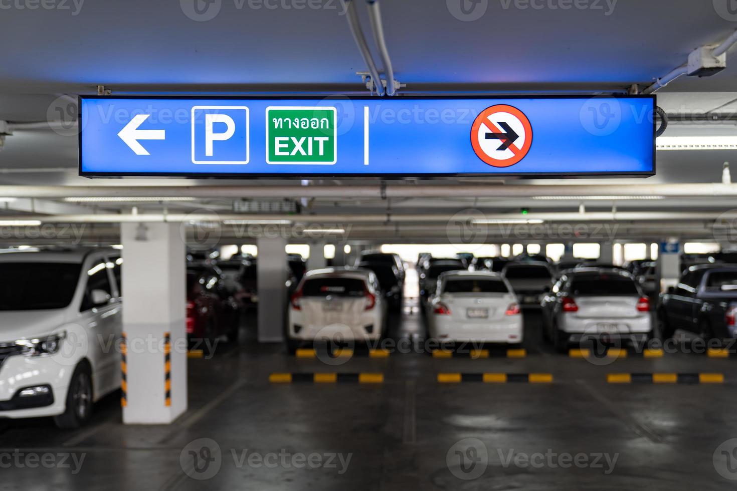 Signage Lightingbox in the indoor carparking, tell driver which way is parking lot or exit. Thai Language in green square on lightinbox means EXIT. photo