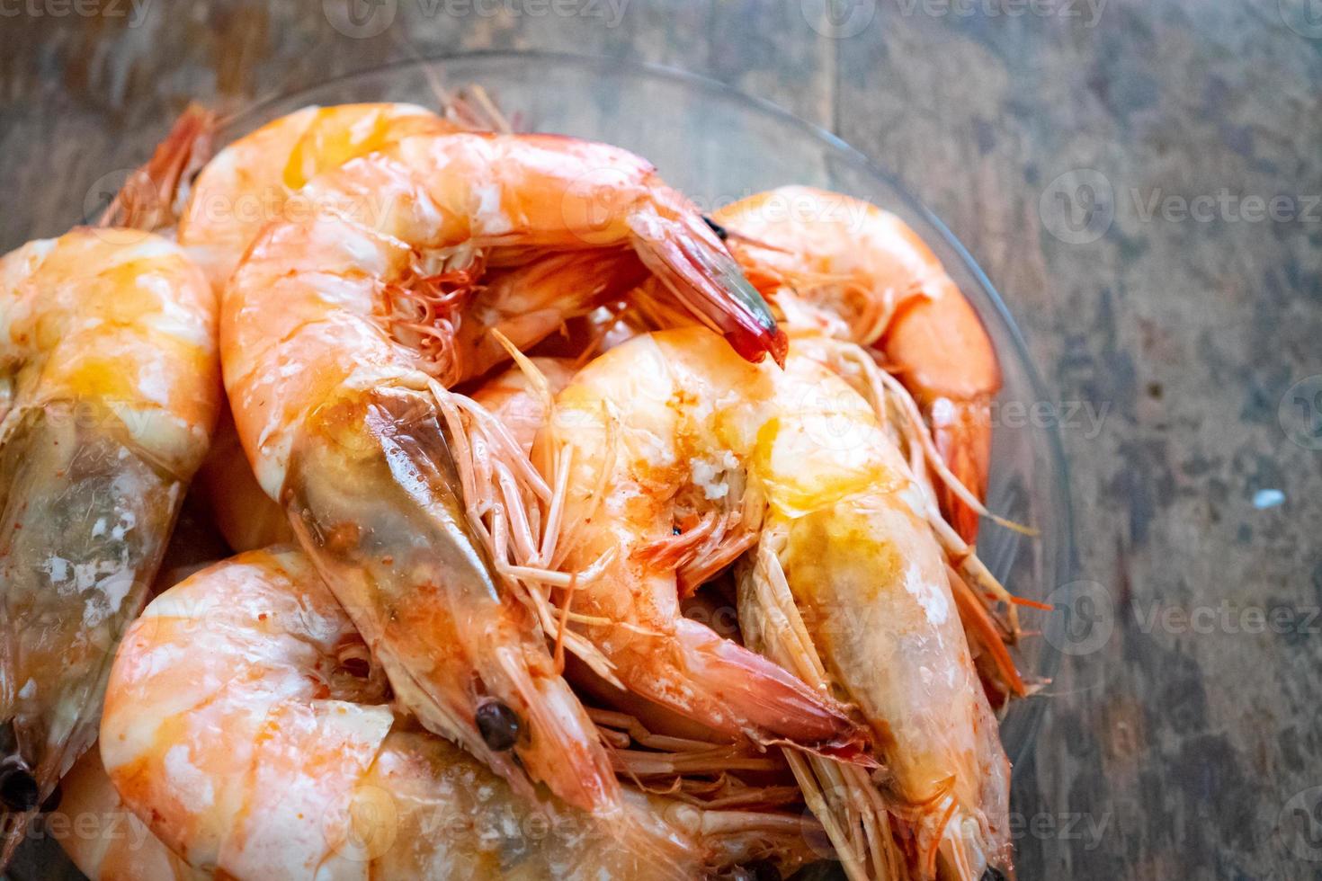 Close up to the Boiled Shrimp in the glass bowl on wooden background. photo
