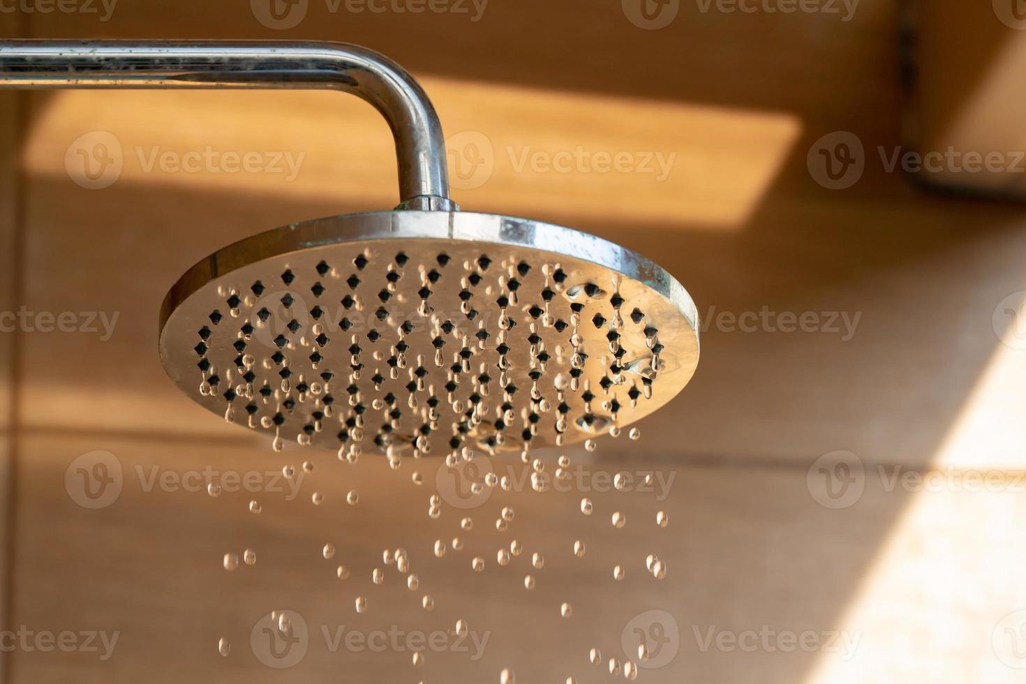 Close up to Outdoor shower head for the bath and showering cold water to body before jumping in the resort pool. photo