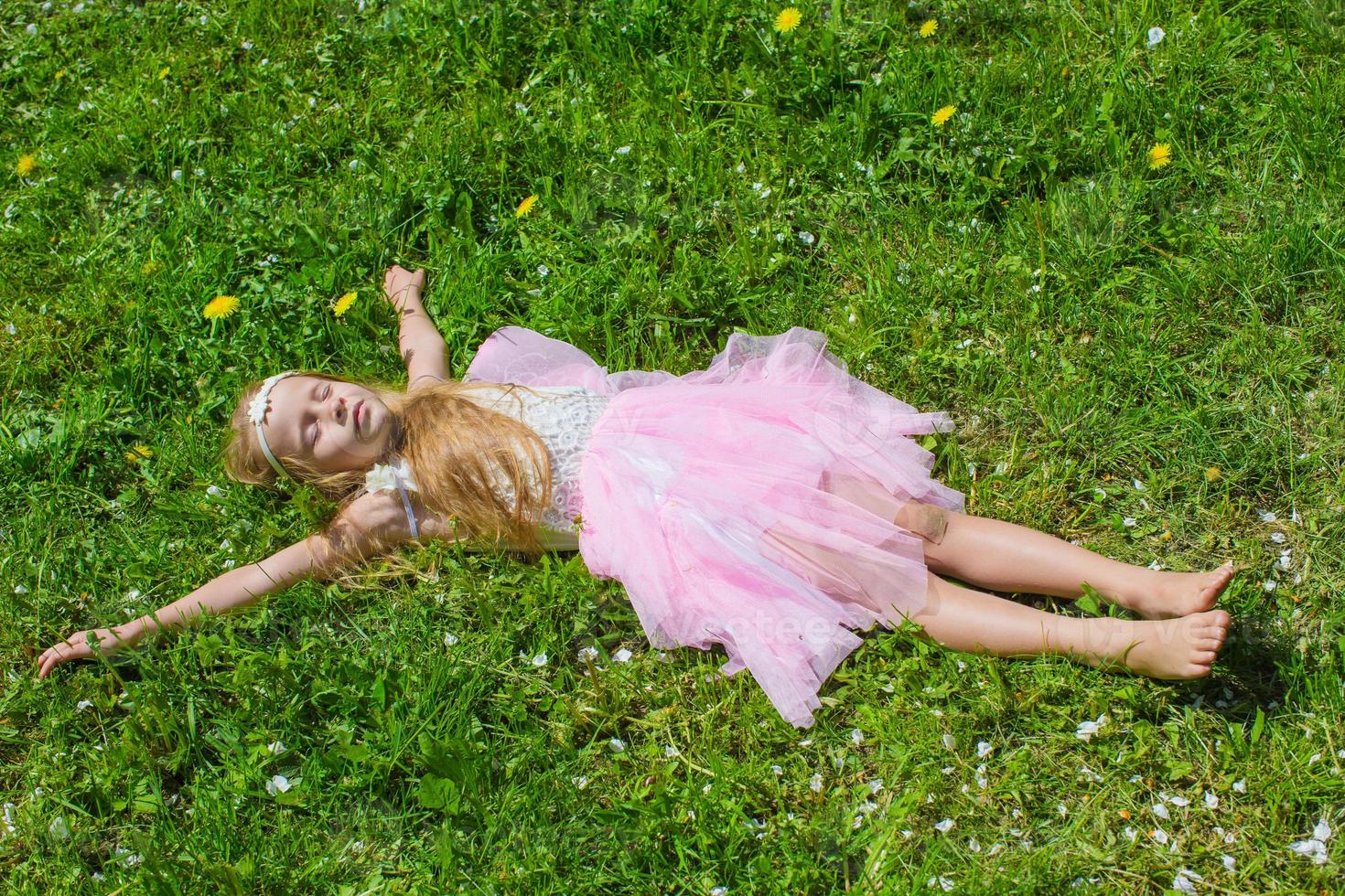 una niña adorable se divierte en el floreciente jardín de manzanos foto