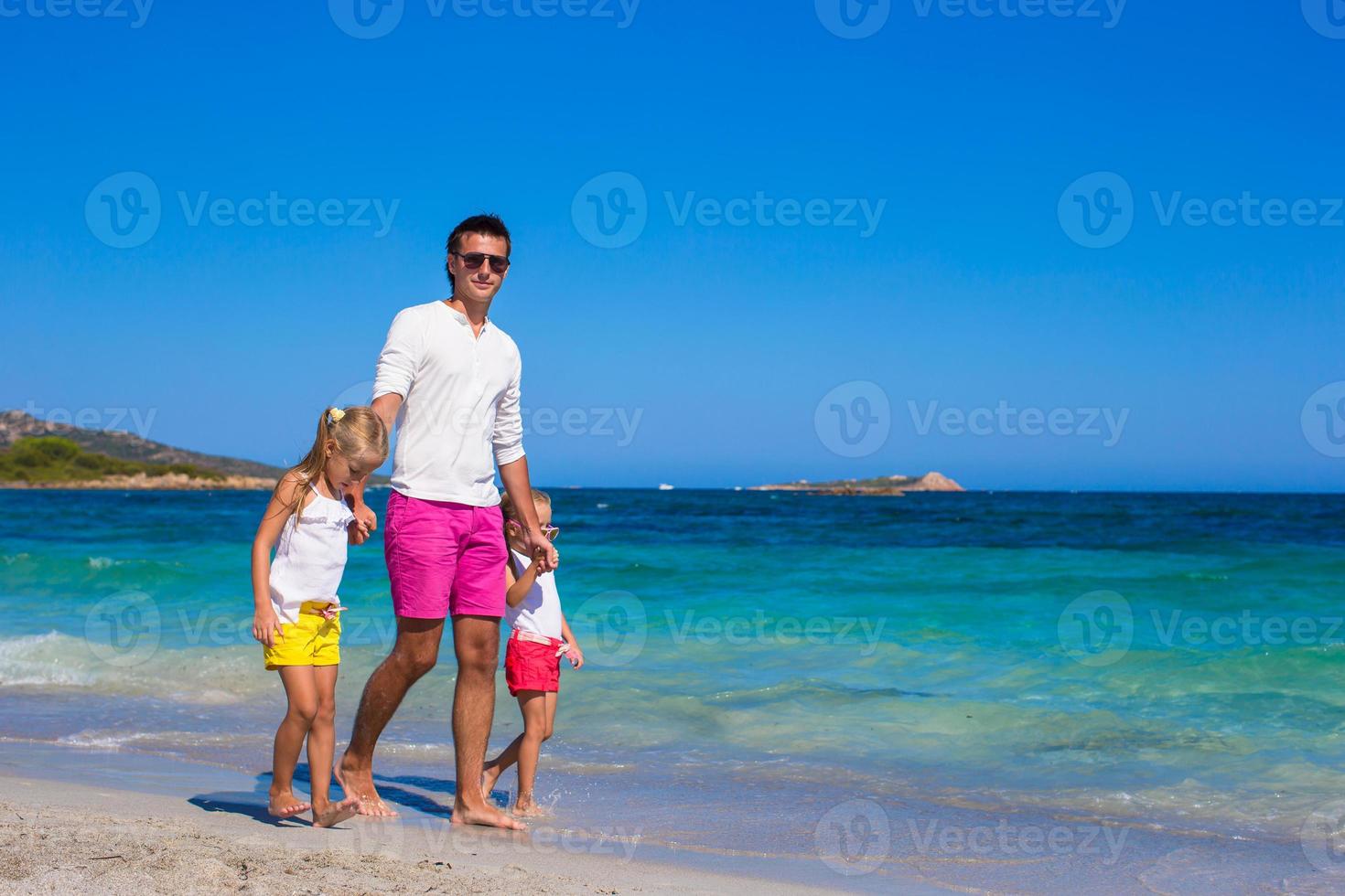 niñas y papá feliz divirtiéndose durante las vacaciones tropicales foto