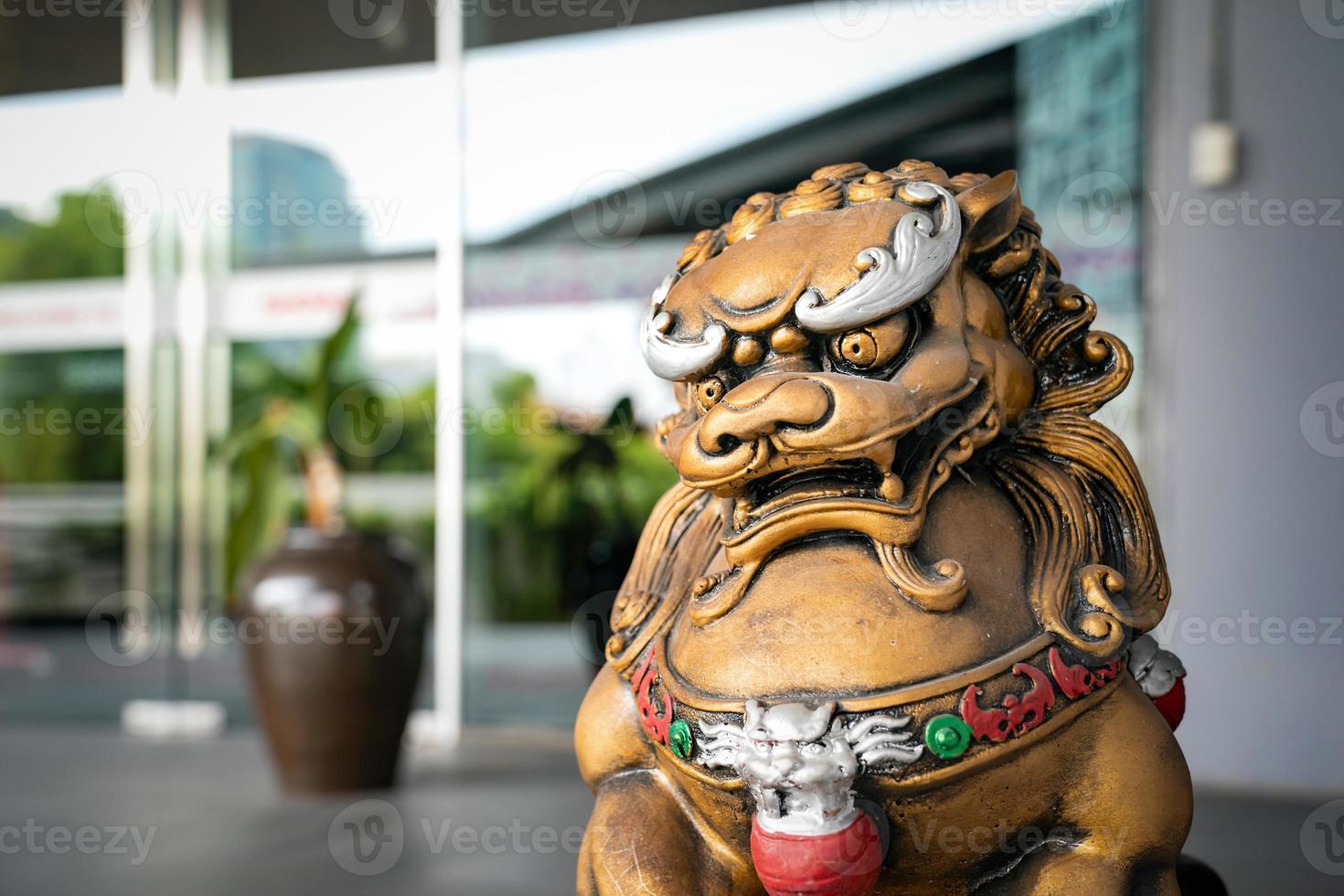 la estatua del león del dios dorado chino es el emperador del ornamento de la estructura zen de asia frente a la puerta para proteger lo malo que entra. foto