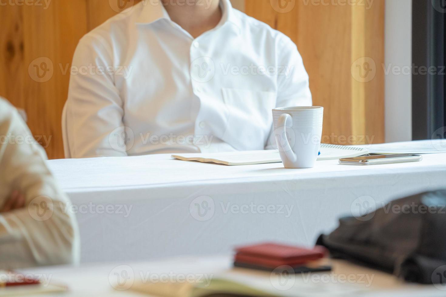 close up to seminar audience with their glass and gadget on the table. photo