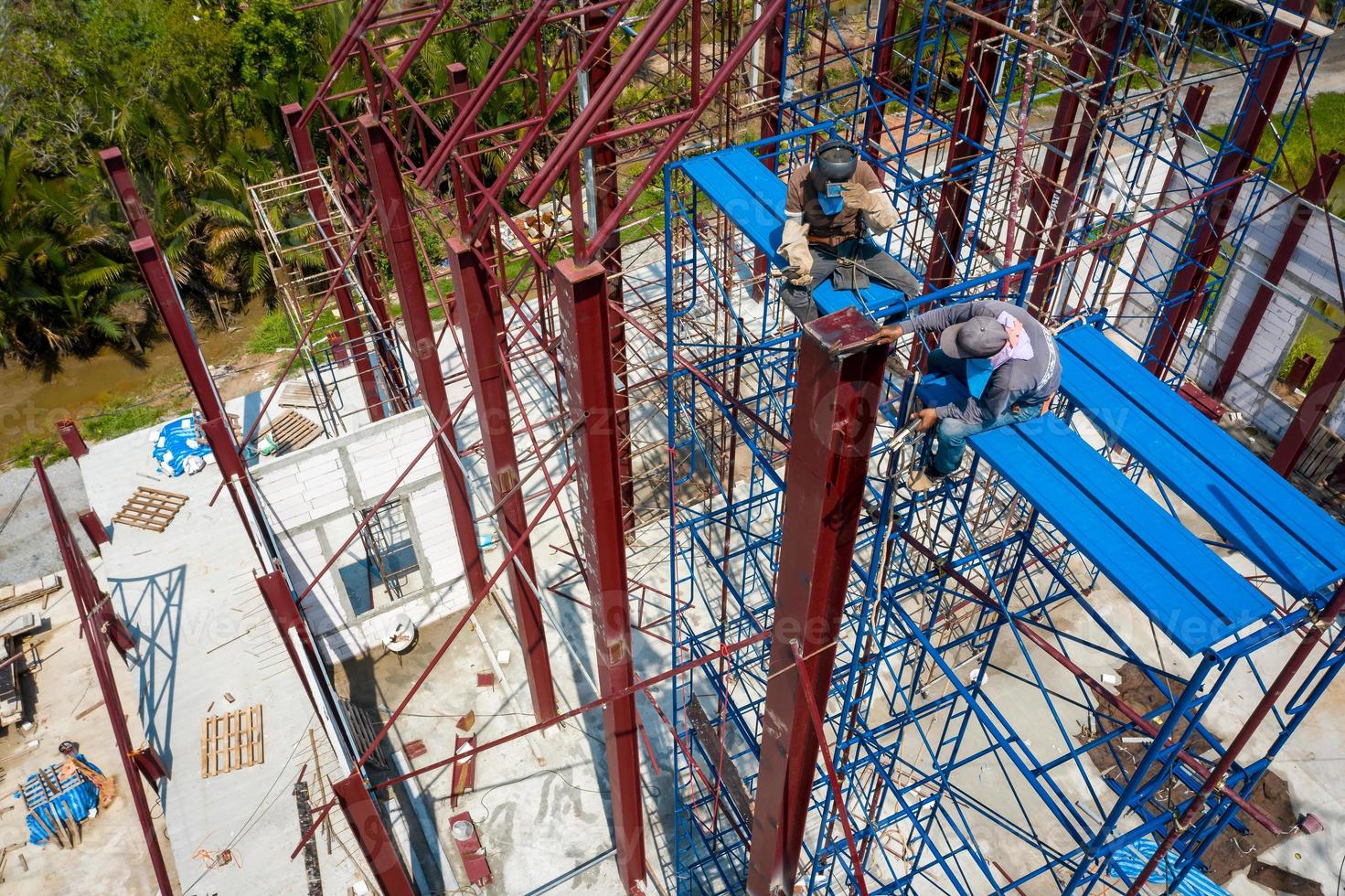 Dual Asian Welder and blacksmith work on the height scaffolding, Shoot from above of them. photo