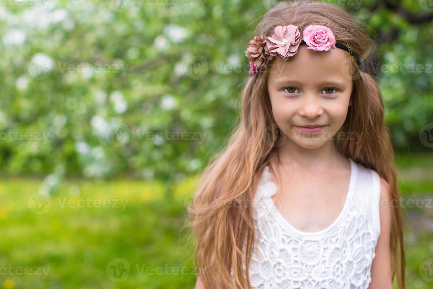 retrato de una niña adorable en un floreciente jardín de manzanas foto