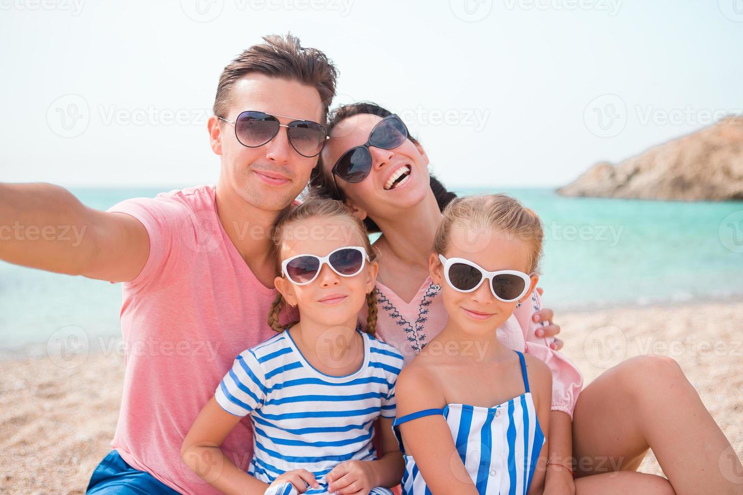 Young beautiful family taking selfie on the beach photo
