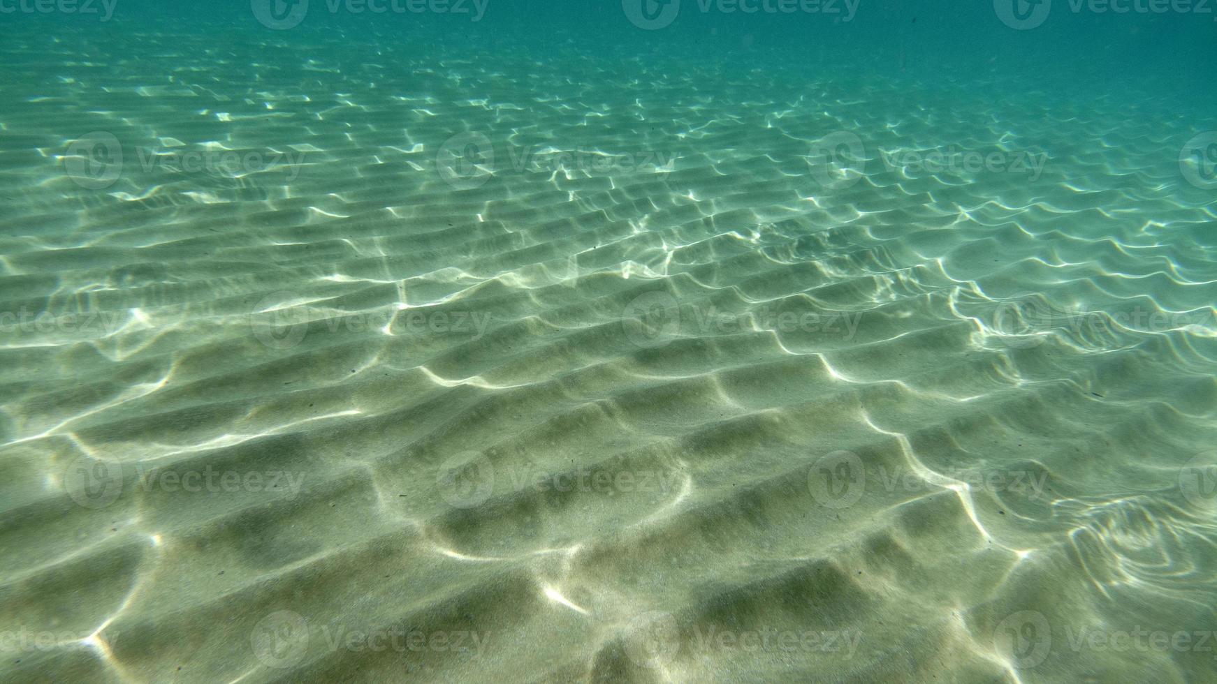 sand bottom underwater swimming in turquoise lagoon photo