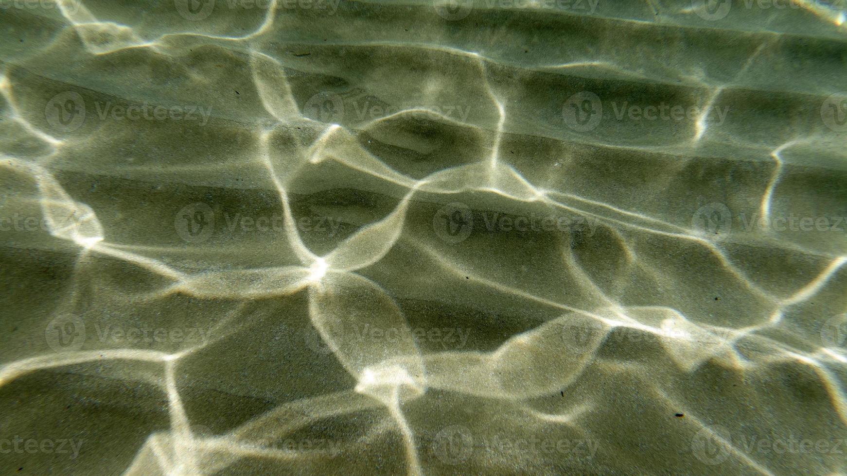 sand bottom underwater swimming in turquoise lagoon photo