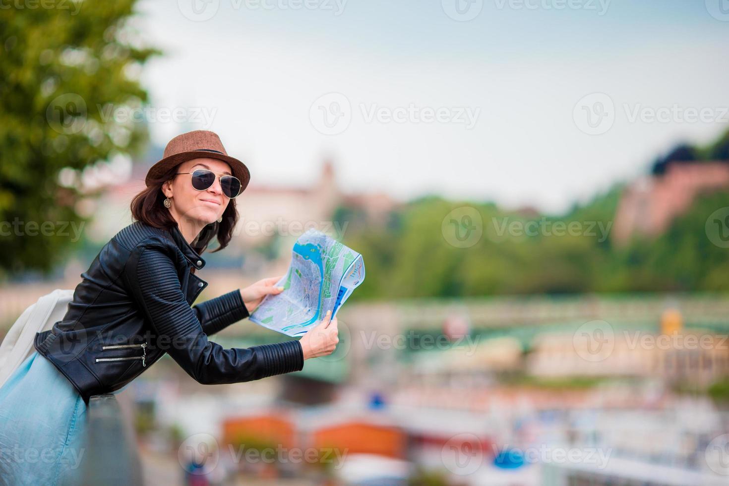 mujer joven feliz con un mapa de la ciudad en europa. viaje mujer turista con mapa en praga al aire libre durante las vacaciones en europa. foto