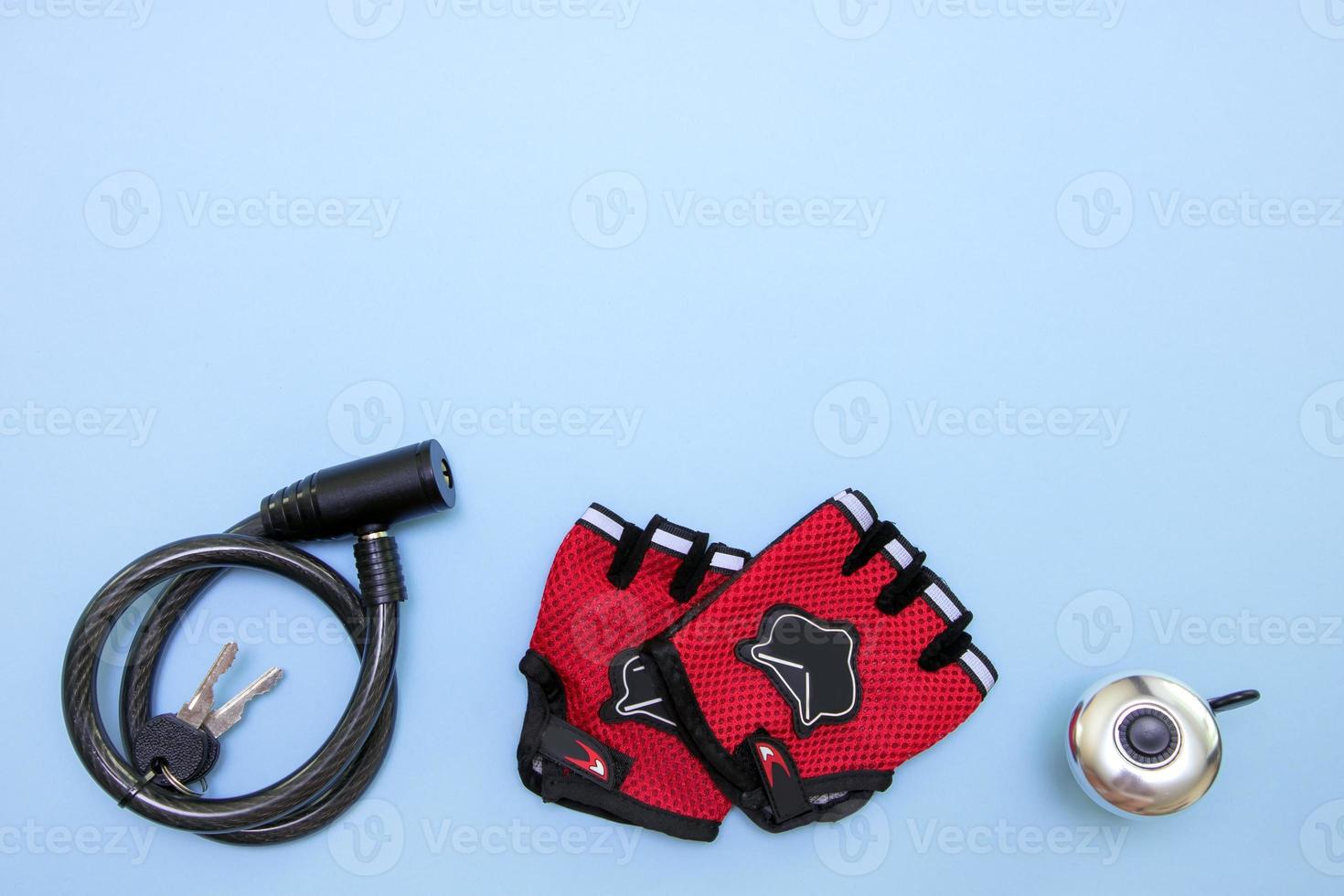 cycling gloves, padlock and bell on a blue background with copy space photo