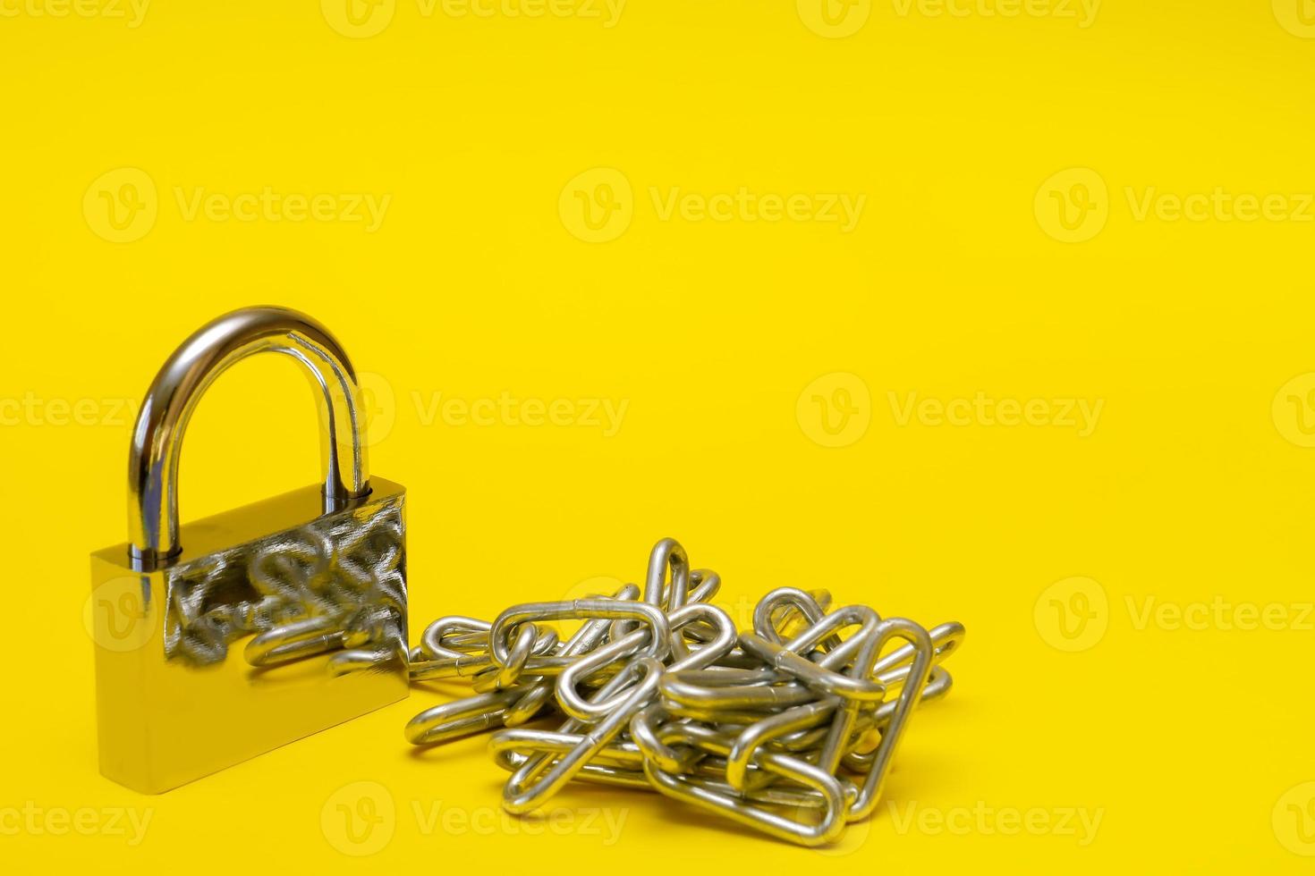padlock with chain on yellow background with copy space photo
