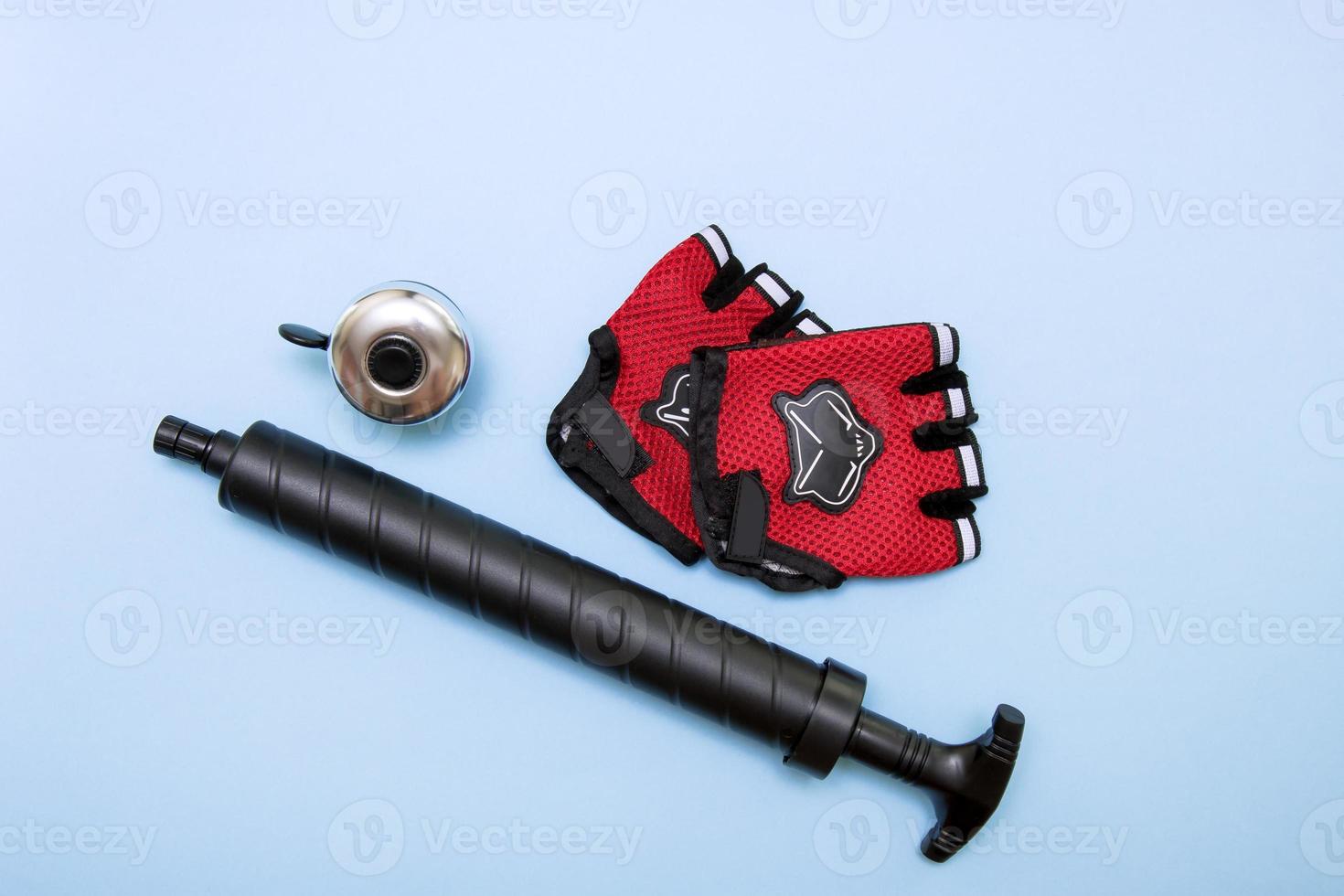 bicycle accessories - gloves, pump, bell, on a blue background photo