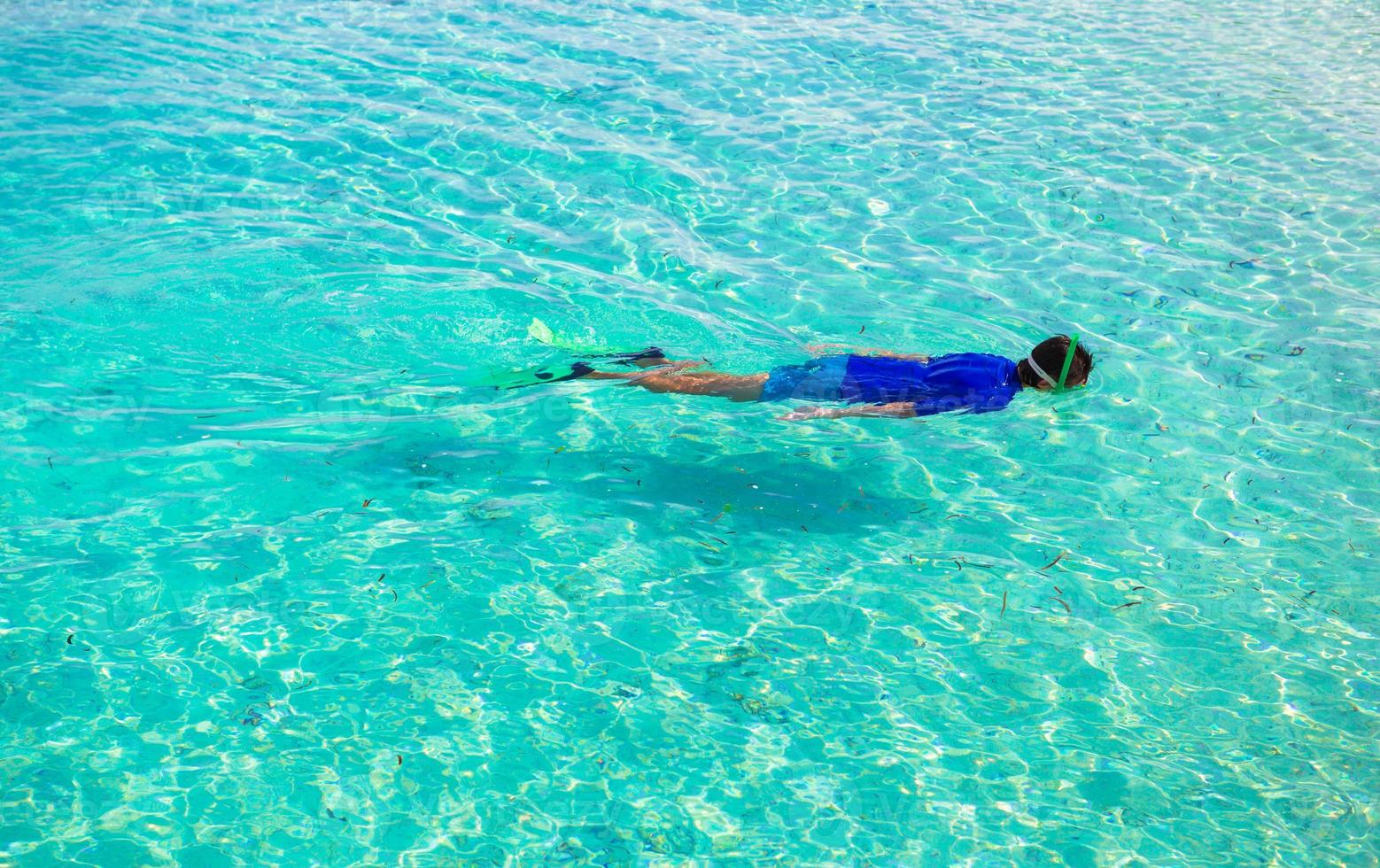 joven buceando en claras aguas turquesas tropicales foto