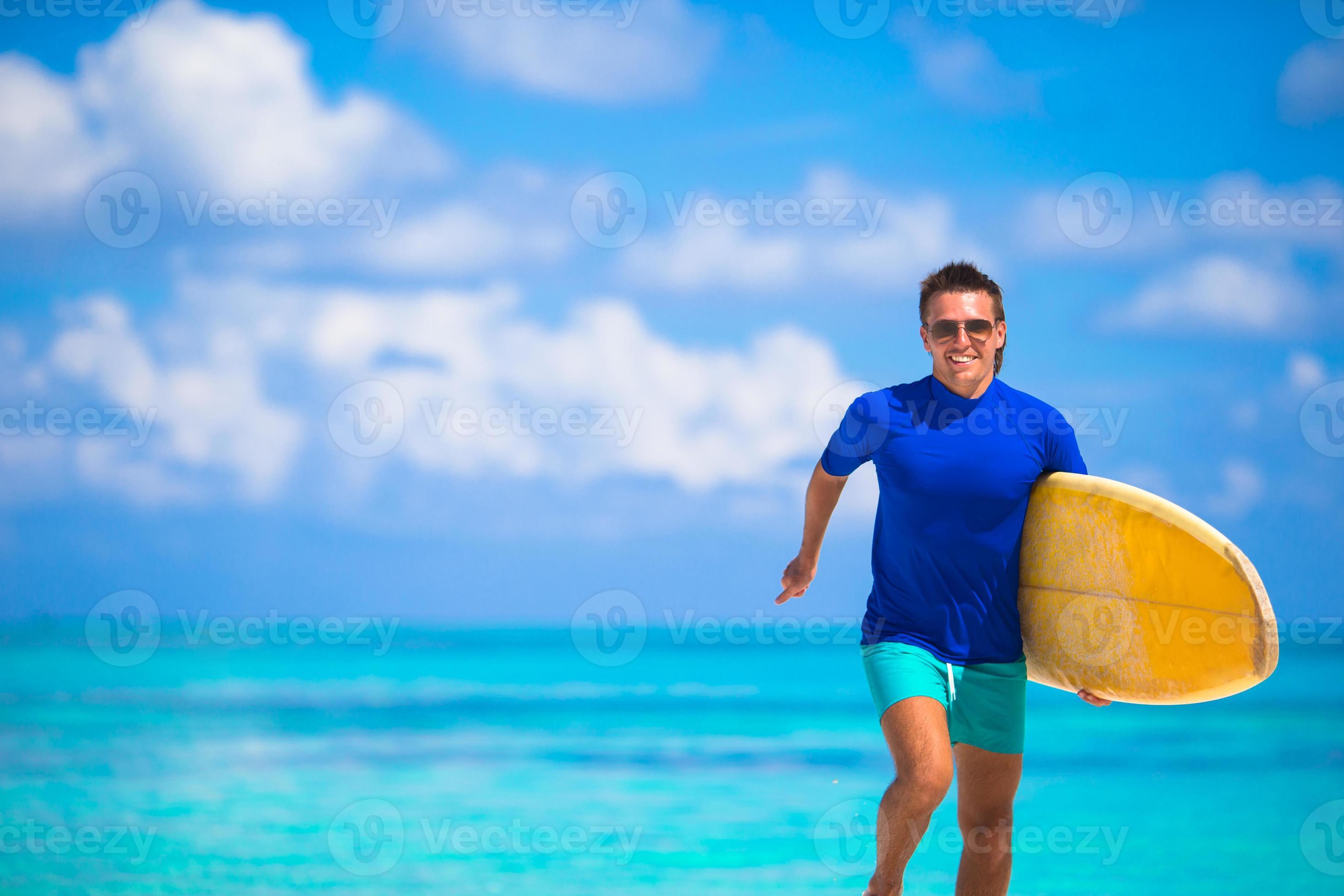 Happy young surf man runing at the beach with a surfboard 18832858