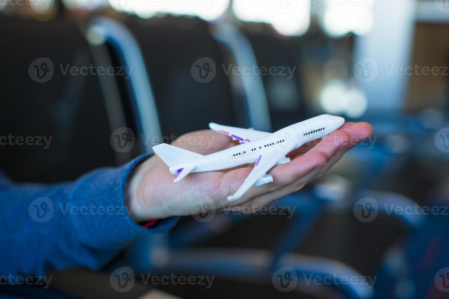 Small airplane model on male hand inside a large aircraft photo