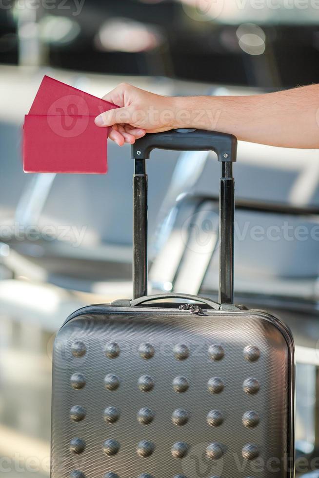 Closeup of man holding passports and boarding pass at airport photo