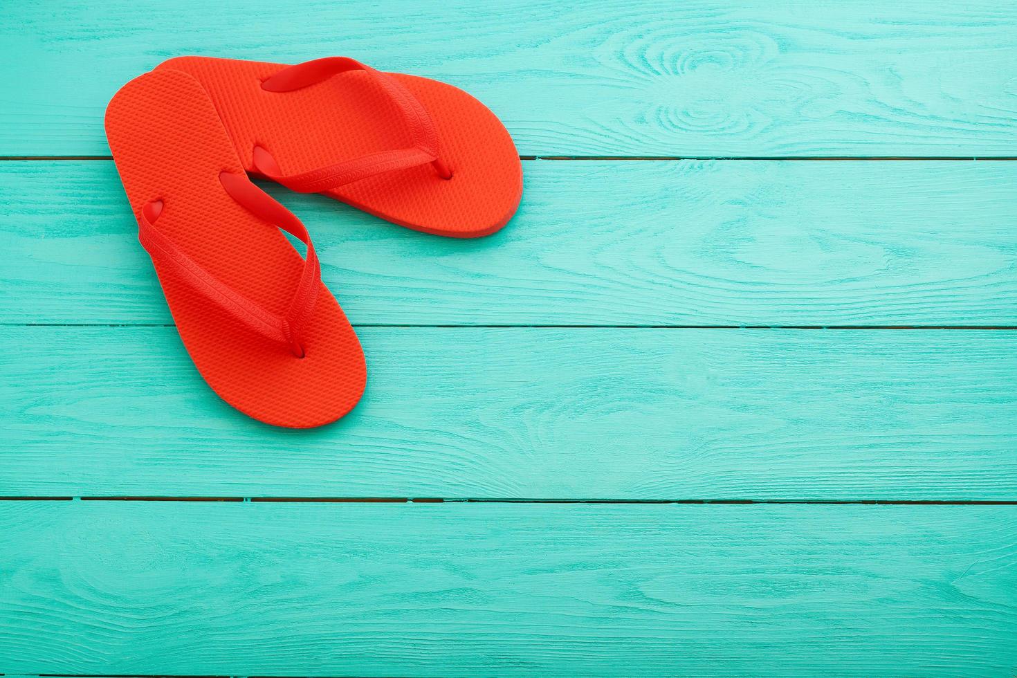 red flip flops on blue wooden background top view free space photo