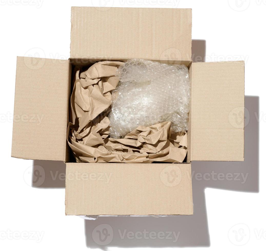 Open cardboard box, inside crumpled paper and polyethylene photo