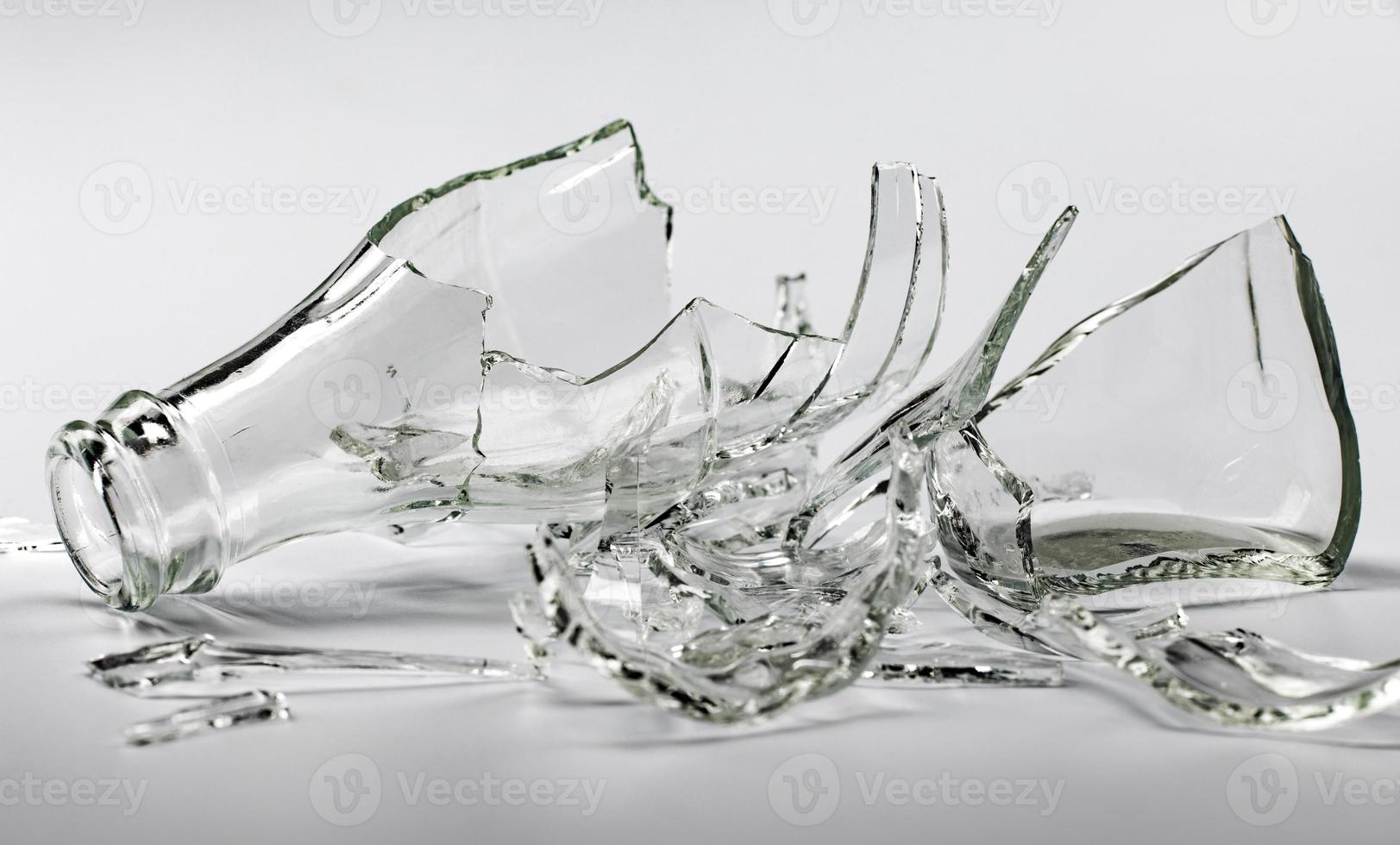 Broken glass bottle. Sharp shards of clear glass. photo